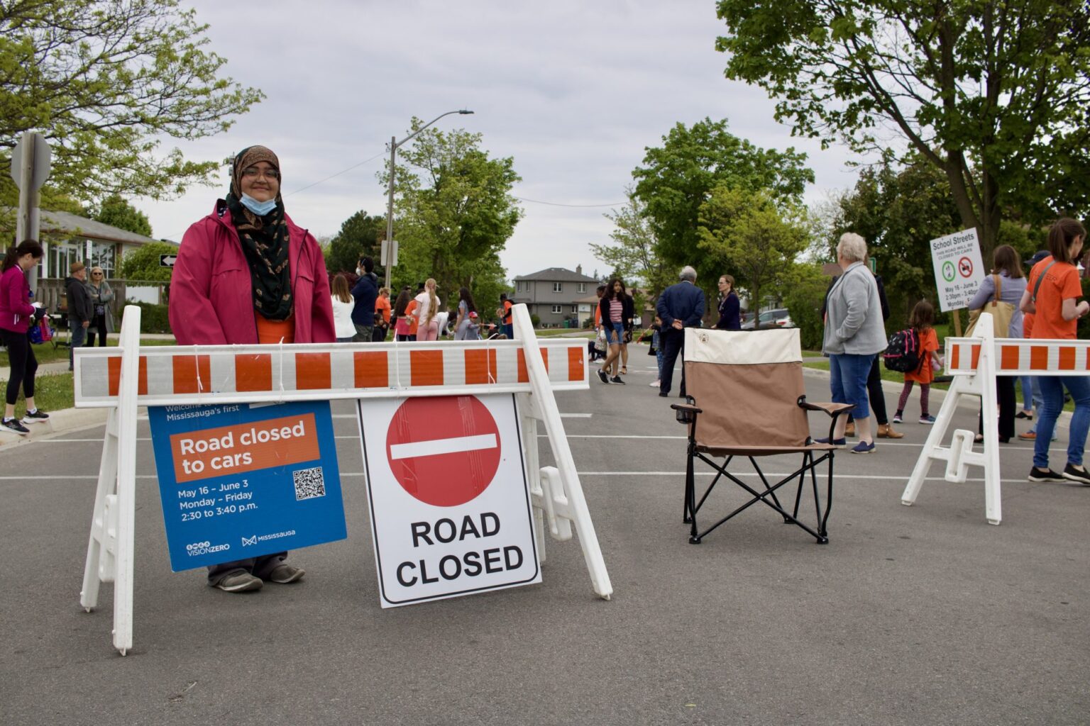 A woman posing in front of a Road Closed sign set up at a School Street