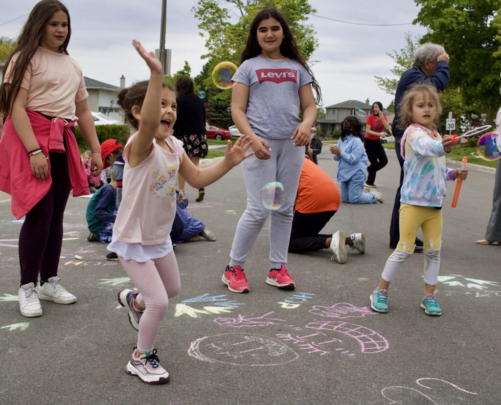 kids playing on pavement covered in sidewalk chalk
