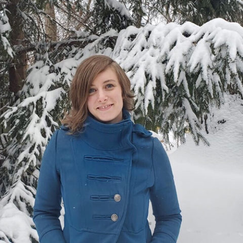 Photo of Britt McKee in front of a snowy tree