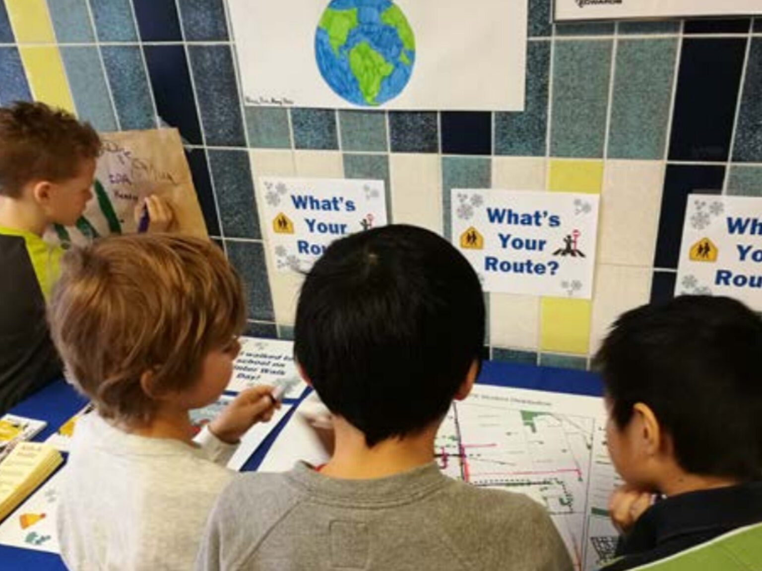 Children looking at maps with signs that say “What’s Your Route?”