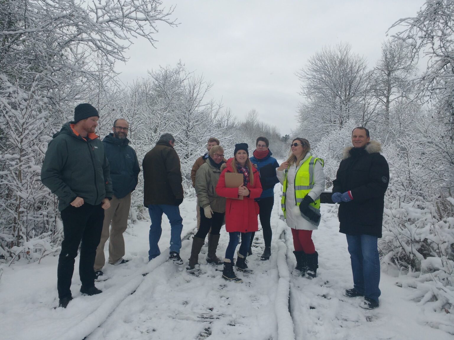 Group of nine people on a snowy trail conducting a walkabout.