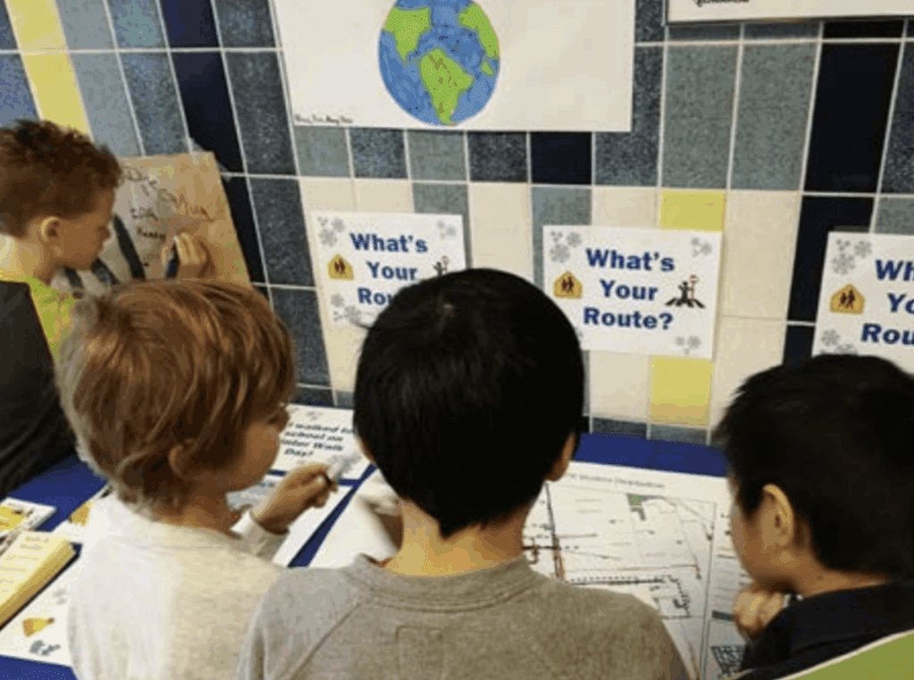 Three kids working together on route-planning activities.